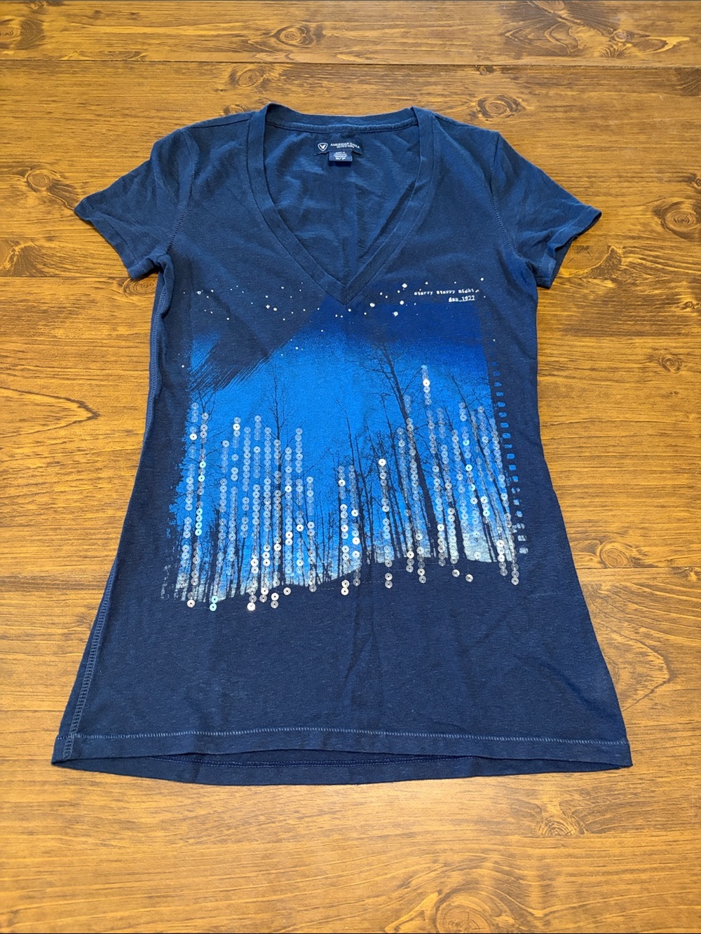 American Eagle Outfitters Navy V‑Neck Tee with Blue Sequin Forest Graphic